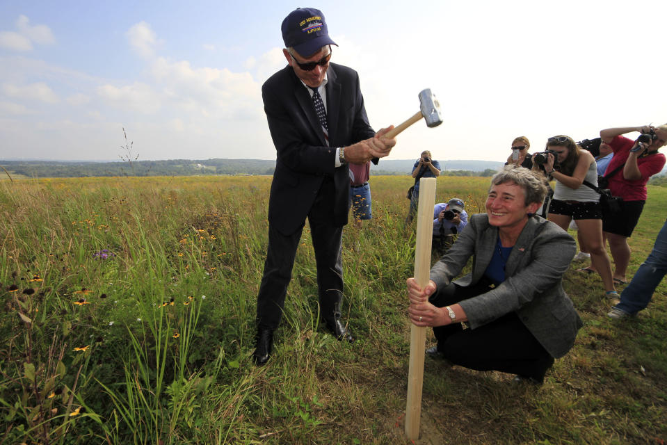 Secretary of the Interior Sally Jewell, lower right, holds a stake as Patrick White, vice president of the Families of Flight 93, pounds it into the ground as part of a ground breaking ceremony for the Flight 93 National Memorial visitor center complex on Tuesday, Sept. 10, 2013, in Shanksville, Pa. (AP Photo/Gene J. Puskar)