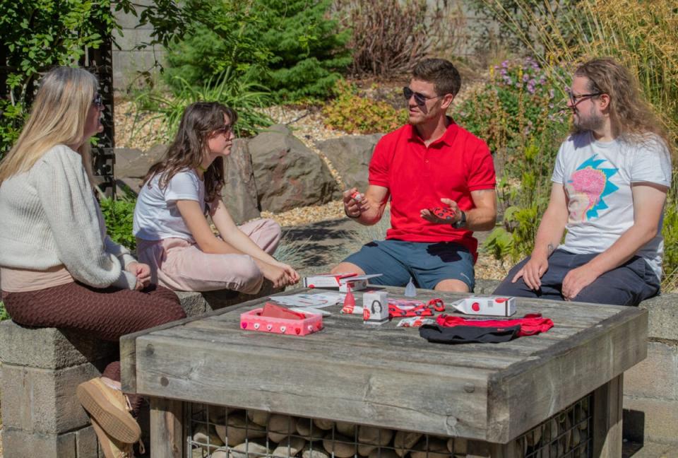 Jason Grant (in red) ‘showcasing’ a range of period products to a mother and daughter (Grainger PR/PA)