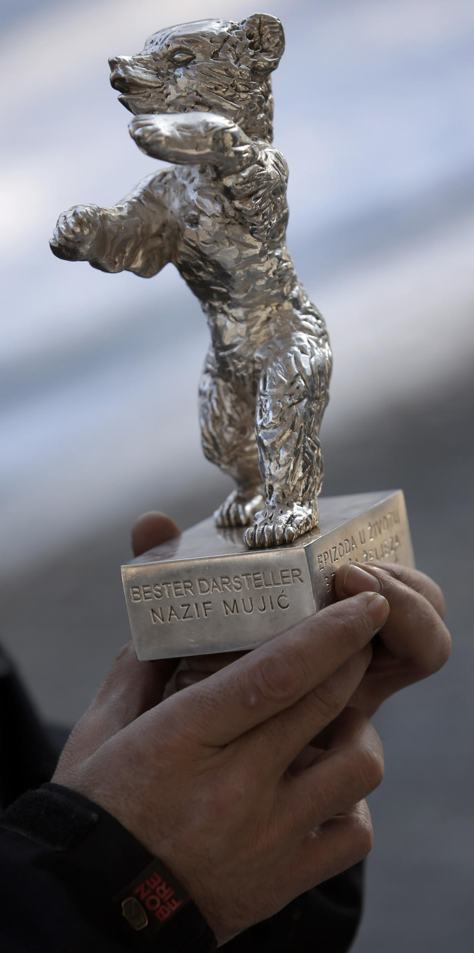 In this photo taken Saturday, Jan. 25, 2014, Bosnian actor Nazif Mujic holds his Silver Bear Best Actor award for his role in 'An Episode In the Life of an Iron Picker' prior to an interview with the Associated Press in Berlin, Germany. Mujic, a Roma from a tiny village in Bosnia, won the Silver Bear award in the year 2013. Now, almost a year later, the movie star has turned into an asylum seeker. Mujic is back in Berlin, but this time he came with his family to apply for asylum, was rejected by the German authorities and is desperately fighting his deportation back to Bosnia in March. (AP Photo/Michael Sohn)