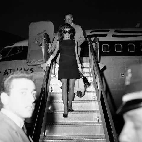 <p>Harry Morrison/WWD/Penske Media via Getty Images</p> Jackie Kennedy Onassis in a black shift dress