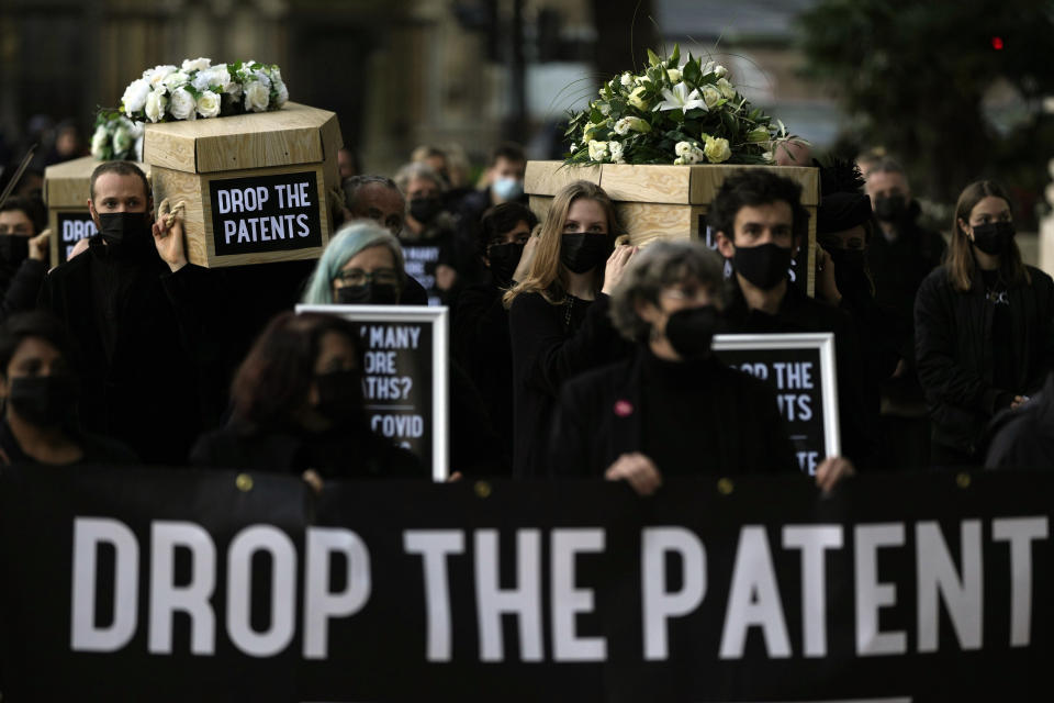 Global Justice campaigners carry fake coffins to highlight the number of COVID-19 deaths globally, in London, Tuesday, Oct. 12, 2021. Britain is taking part in a World Trade Organisation intellectual property meeting to boost the number of vaccinations world wide. The campaigners want large pharmaceuticals companies to drop patents on COVID-19 drugs to allow poorer nations to vaccinate their populations. (AP Photo/Alastair Grant)