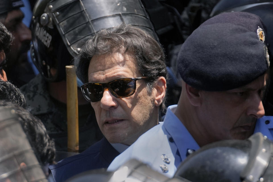 Pakistan's former Prime Minister Imran Khan, center, is escorted by police officers as he arrives to appear in a court, in Islamabad, Pakistan, Friday, May 12, 2023. A high court in Islamabad has granted Khan a two-week reprieve from arrest in a graft case and granted him bail on the charge. (AP Photo/Anjum Naveed)