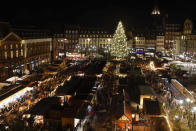 FILE - Visitors stroll around Strasbourg's Christmas market, one of the oldest and biggest Christmas markets in Europe. Strasbourg, eastern France, Nov. 25, 2022. In cities across Europe, officials are wrestling with a choice this Christmas. Dim lighting plans to send a message of energy conservation and solidarity with citizens squeezed by both higher energy costs and inflation or let the lights blaze in a message of defiance after two years of pandemic-suppressed Christmas seasons, creating a mood that retailers hope loosen holiday purses. (AP Photo/Jean-Francois Badias, File)