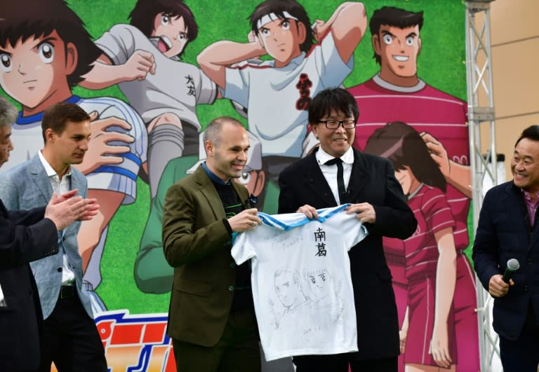 El futbolista español Andrés Iniesta posa con el artista Yoichi Takahashi, creador de la manga "Supercampeones", en una estación del metro de Tokio, el 4 de marzo de 2019 (Kazuhiro NOGI)