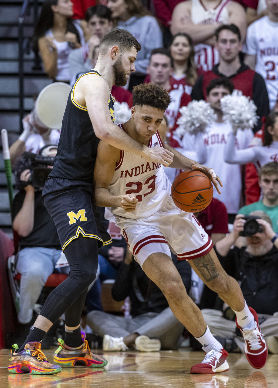 Indiana forward Trayce Jackson-Davis (23) drives into the defense of Michigan center Hunter Dickinson, left, during the first half of an NCAA college basketball game, Sunday, March 5, 2023, in Bloomington, Ind. (AP Photo/Doug McSchooler)