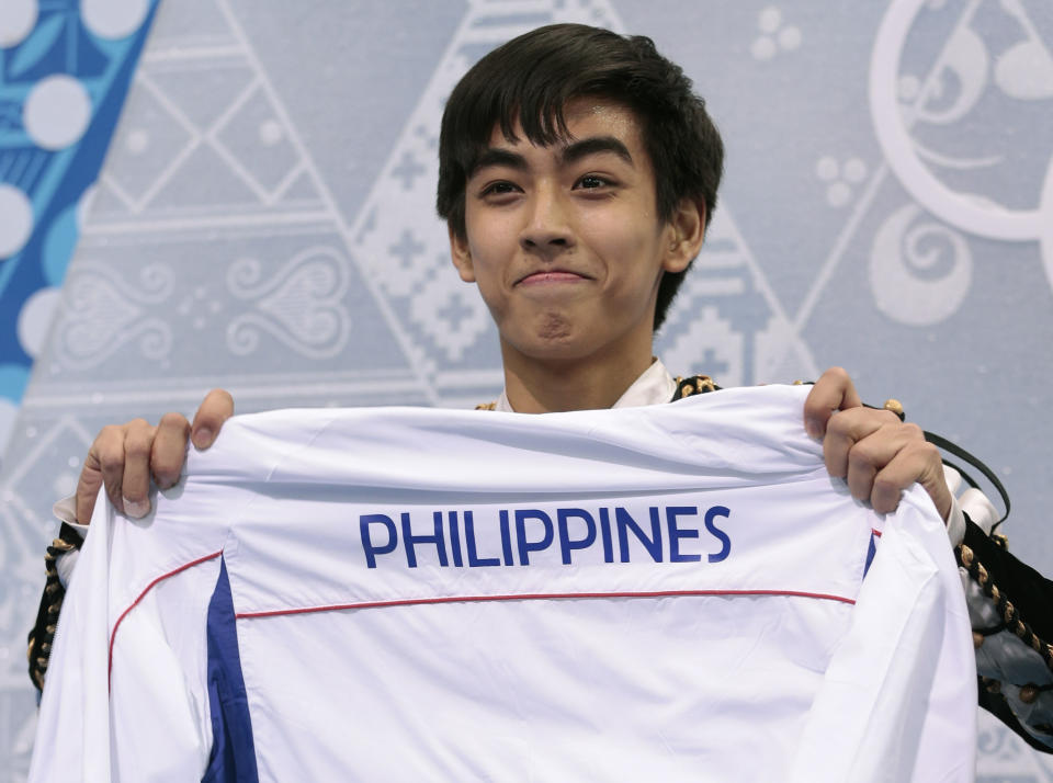 Michael Christian Martinez of the Philippines holds up a jacket after the men's short program figure skating competition at the Iceberg Skating Palace during the 2014 Winter Olympics, Thursday, Feb. 13, 2014, in Sochi, Russia. (AP Photo/Ivan Sekretarev)