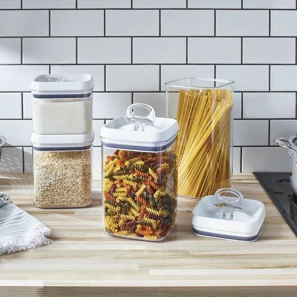 a four-piece food container set holding pasta and rice