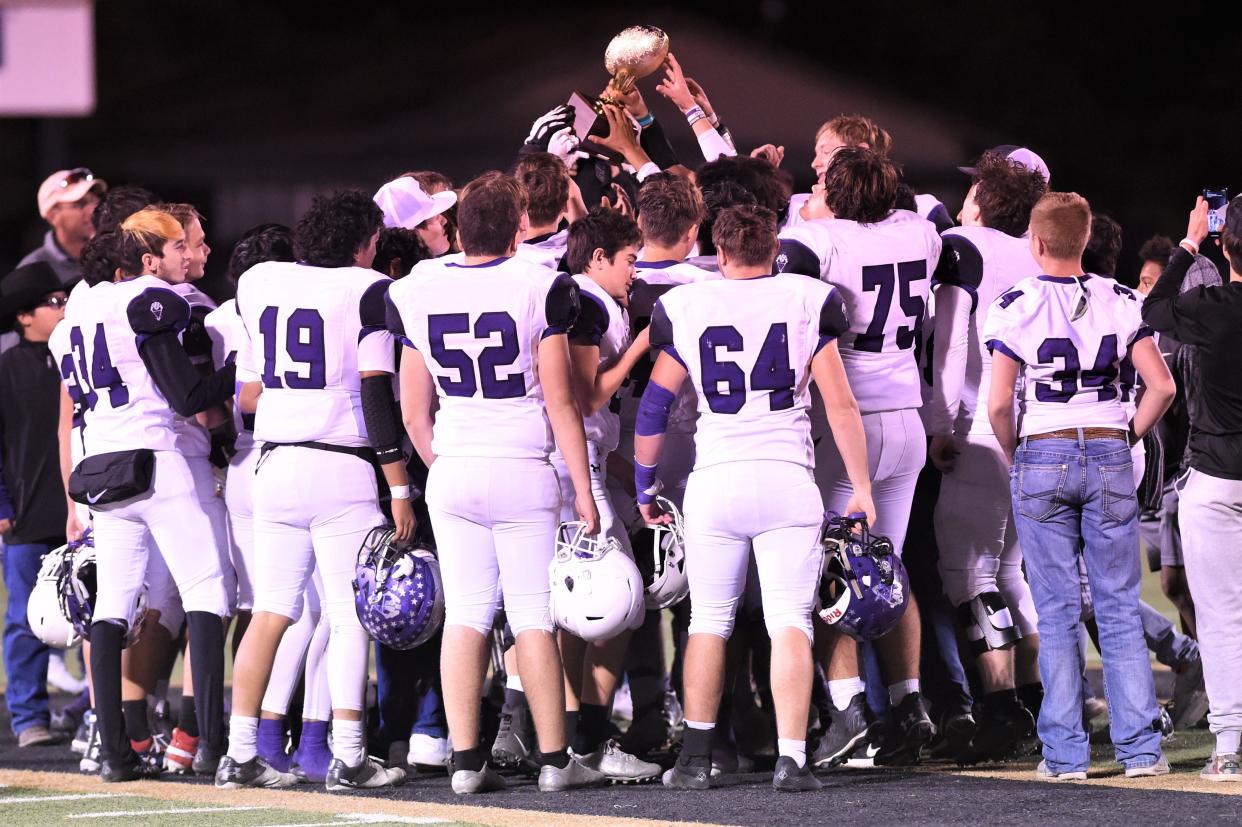 The Roscoe football team celebrates with the Region II-2A Division II bi-district playoff trophy after beating Quanah on Nov. 11 at Post.