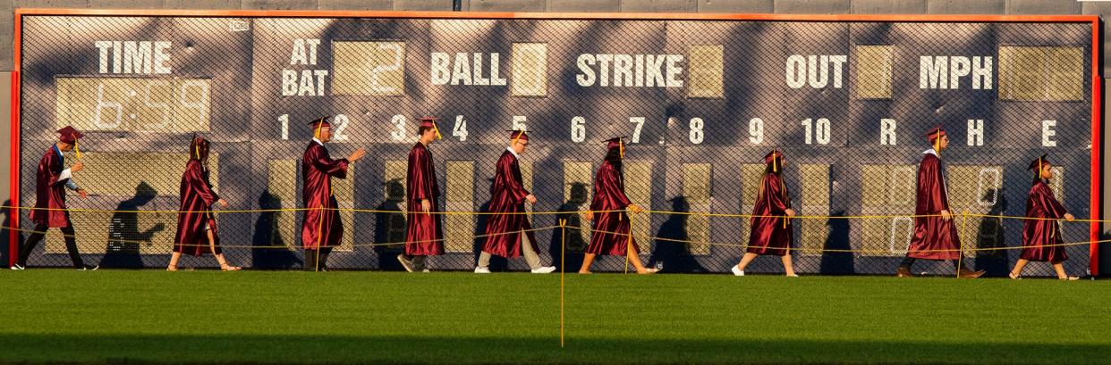 Graduates walk past the outfield scoreboard towards the stage to receive their diplomas during the Doherty Memorial High School commencement at Polar Park Monday, June 7, 2021. This photograph by Telegram & Gazette chief photographer Rick Cinclair placed first in the General News Photo category of the New England Newspaper & Press Association's Better Newspaper Competition.