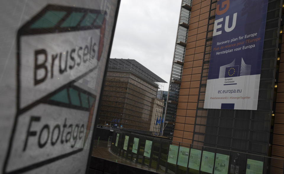 European Union flags flutter in the breeze outside EU headquarters in Brussels, Thursday, Dec. 24, 2020. European Union and British negotiators worked through the night and into Christmas Eve in the hopes of putting the finishing touches on a trade deal that should avert a chaotic economic break between the two sides on New Year's Day. (AP Photo/Virginia Mayo)