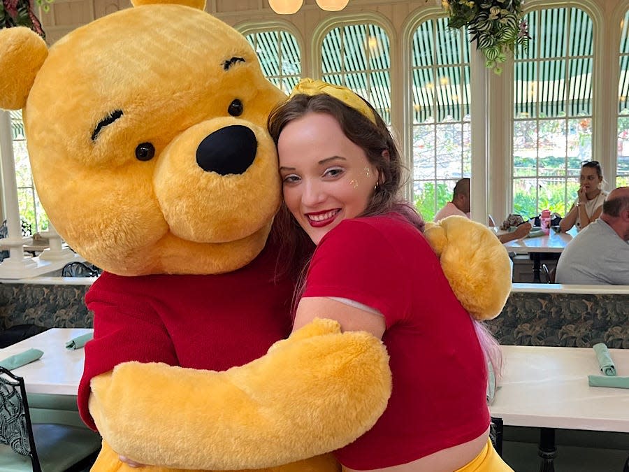 jenna hugging pooh bear at crystal palace in magic kingdom at disney world
