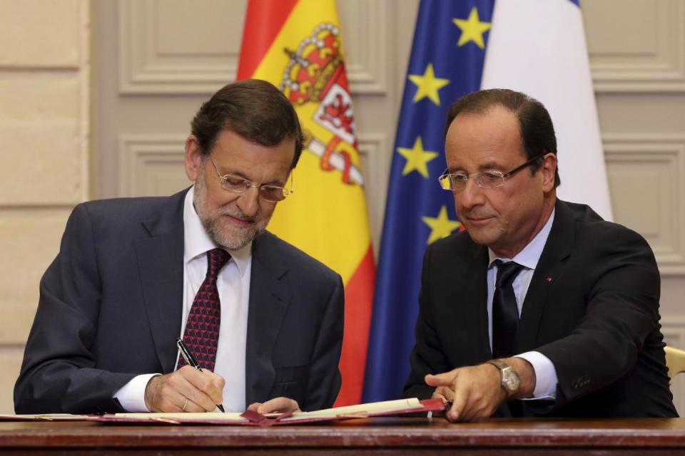 Spain's Prime Minister Mariano Rajoy, left, and French President Francois Hollande, sign cooperation agreements during a Franco-Spanish summit at the Elysee Palace, in Paris, Wednesday, Oct. 10, 2012. (AP Photo/Philippe Wojazer, Pool)