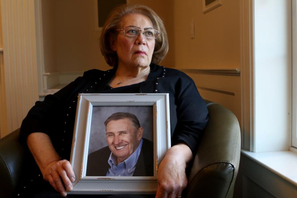 Carol Alamia poses for a picture as she holds an image of her husband, who died from COVID-19.  Monday, Feb. 22, 2021