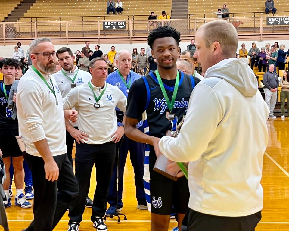 Wyoming sophomore Kellen Wiley accepts the regional runner-up trophy after Wyoming lost 63-36 to Alter in the OHSAA Division II, Region 8 boys basketball championship game Saturday.