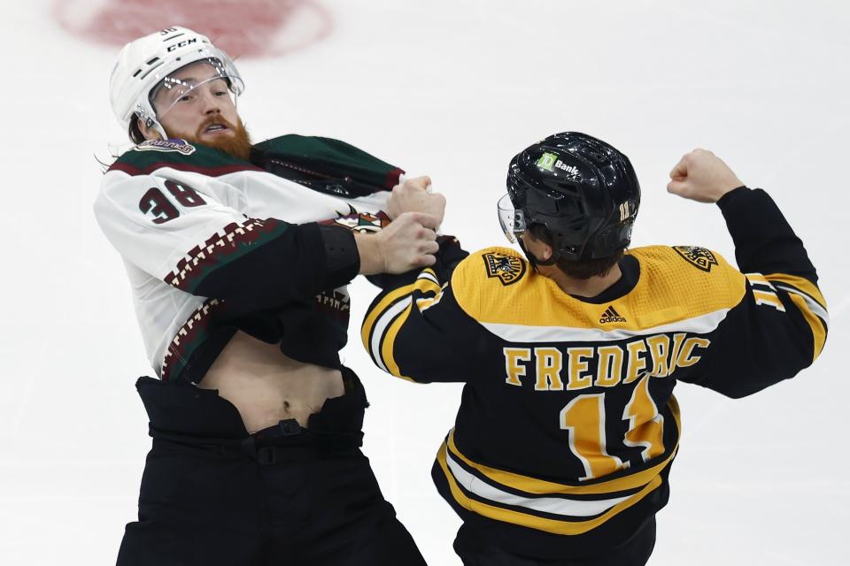 Boston Bruins' Trent Frederic (11) and Arizona Coyotes' Liam O'Brien (38) fight during the second period of an NHL hockey game, Saturday, Oct. 15, 2022, in Boston. (AP Photo/Michael Dwyer)