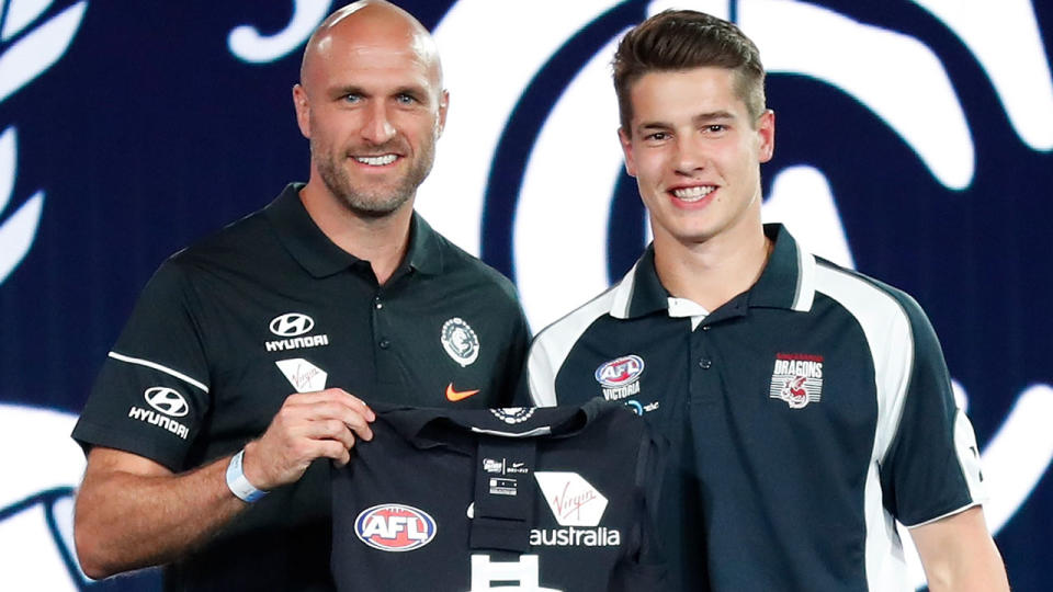 Liam Stocker (right) poses with Chris Judd. (Photo by Michael Willson/AFL Media/Getty Images)