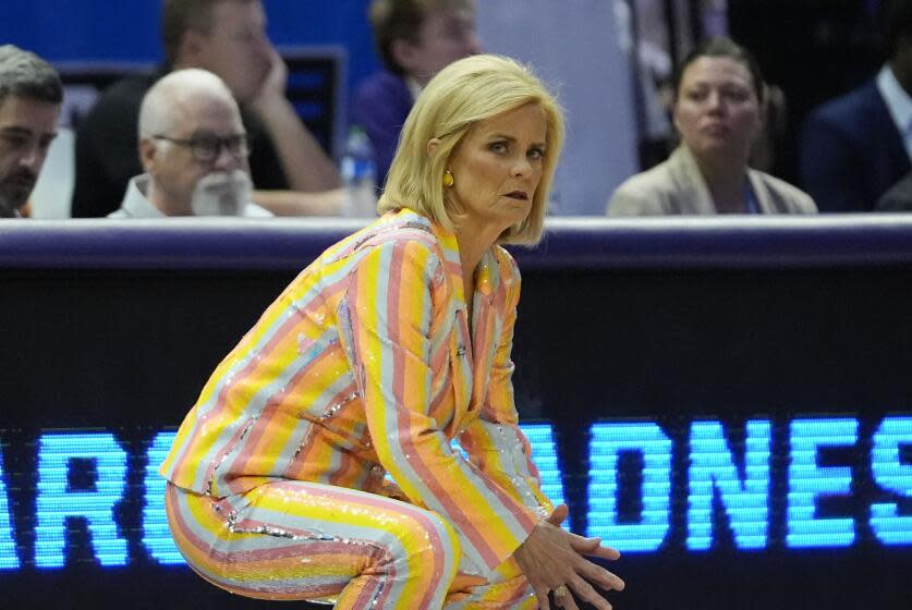 LSU coach Kim Mulkey crouches down and watches from the sideline during an NCAA tournament game against Middle Tennessee