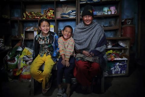 Laxmi Lama, 35, with her son and daughter at her food store in Solambu village, Chauri Deurali Rural Municipality, Kavrepalanchok District, Nepal - Credit: Bikram Rai 