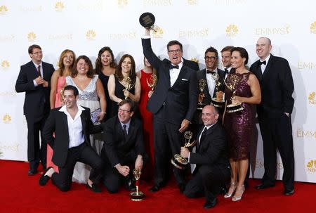 Stephen Colbert (C) with the the executives and crew pose with their Outstanding Variety Series award for Comedy Central's "The Colbert Report" at the 66th Primetime Emmy Awards in Los Angeles, California August 25, 2014. REUTERS/Mike Blake