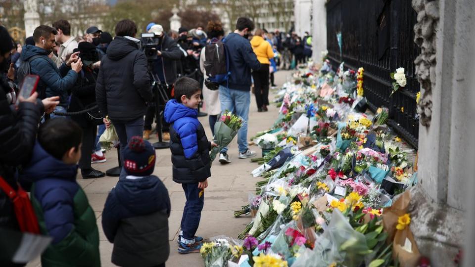 Personas dejan flores y recuerdos a las puertas del palacio de Buckingham