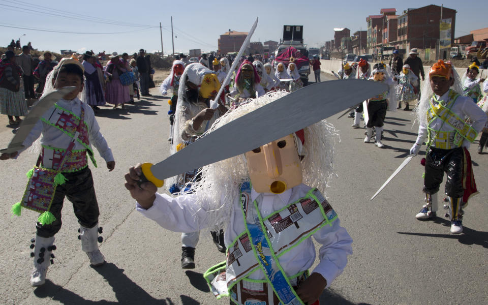 Un niño interpreta un baile mientras usa una máscara hecha con plástico durante un festival de danzas folclóricas y autóctonas para crear conciencia ambiental y de reciclaje en El Alto, Bolivia, el martes 14 de agosto de 2018. (AP Photo/Juan Karita)