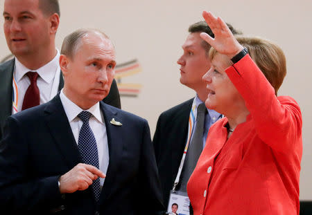 FILE PHOTO: German Chancellor Angela Merkel talks to Russia's President Vladimir Putin at the start of the first working session of the G20 meeting in Hamburg, Germany, July 7, 2017. REUTERS/Kay Nietfeld/Pool/File Photo