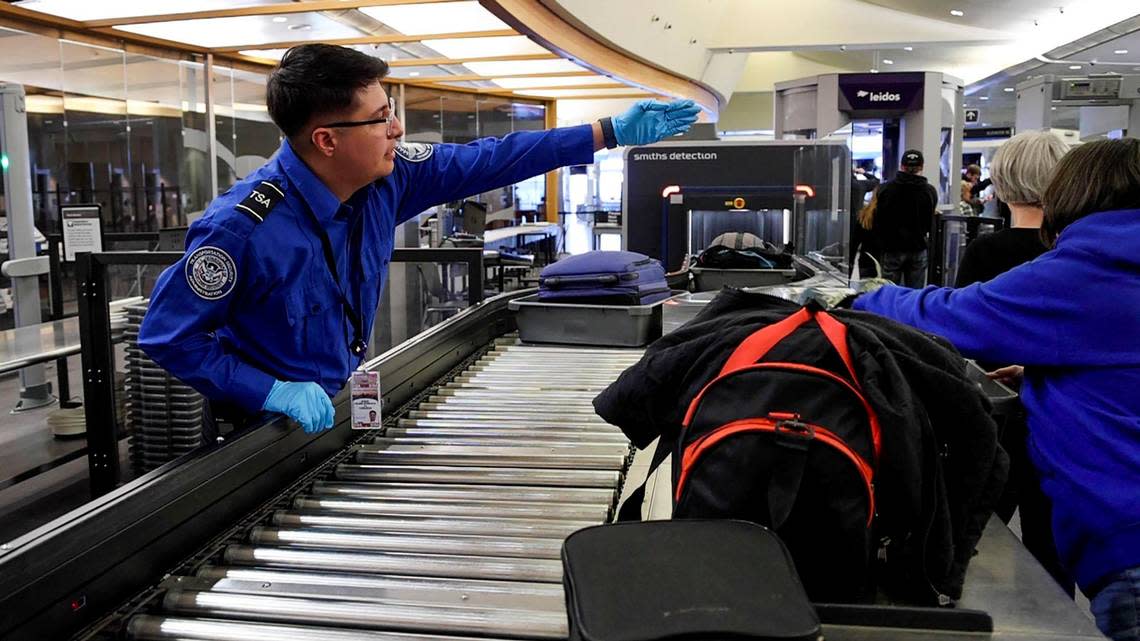 Travelers place bags and items in trays for screening at a TSA checkpoint at the Boise Airport, Tuesday, Jan. 10, 2023.
