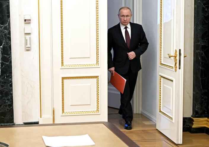 Russian President Vladimir Putin enters a hall to chair a Security Council meeting in Moscow on Feb. 25, 2022.