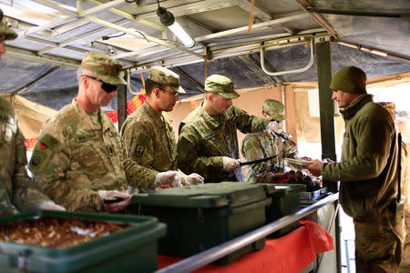 U.S. soldiers serve food to fellow soldiers as they celebrate Thanksgiving Day inside the U.S. army base in Qayyara, south of Mosul, Iraq November 24, 2016. REUTERS/Thaier Al-Sudani