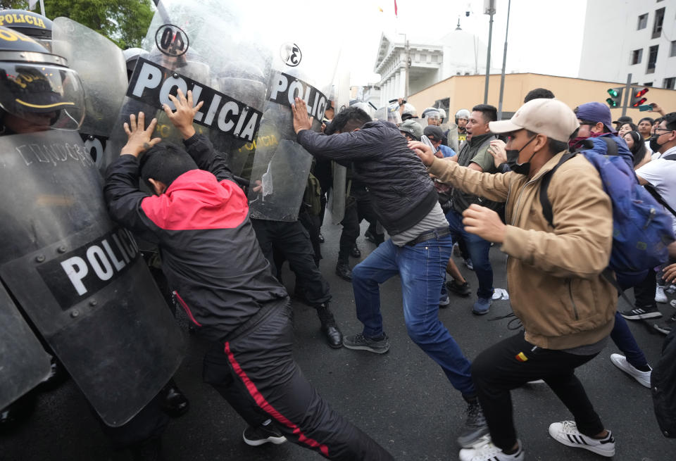 Supporters of ousted President Pedro Castillo clash with police during a protest in Lima, Peru, Thursday, Dec. 8, 2022. Peru's Congress voted to remove Castillo from office Wednesday and replace him with the vice president, shortly after Castillo tried to dissolve the legislature ahead of a scheduled vote to remove him. (AP Photo/Fernando Vergara)