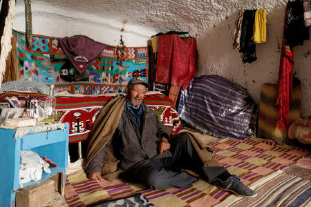 Tayeb, 76, sits inside his troglodyte home in Matmata, Tunisia, February 5, 2018. "Our home was open for tourists to visit, but now with the lack of tourists we don't earn anything. I don't want to leave my house, it's where I grew up," Tayeb said. REUTERS/Zohra Bensemra