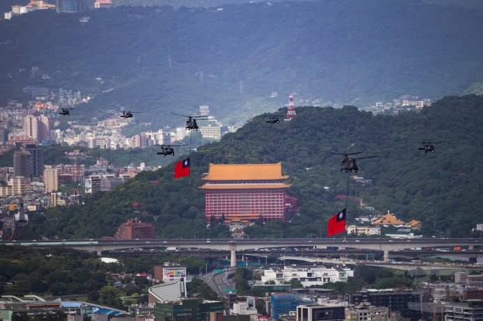 吊掛國旗的CH-47SD運輸直升機搭配UH-60M黑鷹直升機編隊。（軍聞社記者黃劭恩攝） 