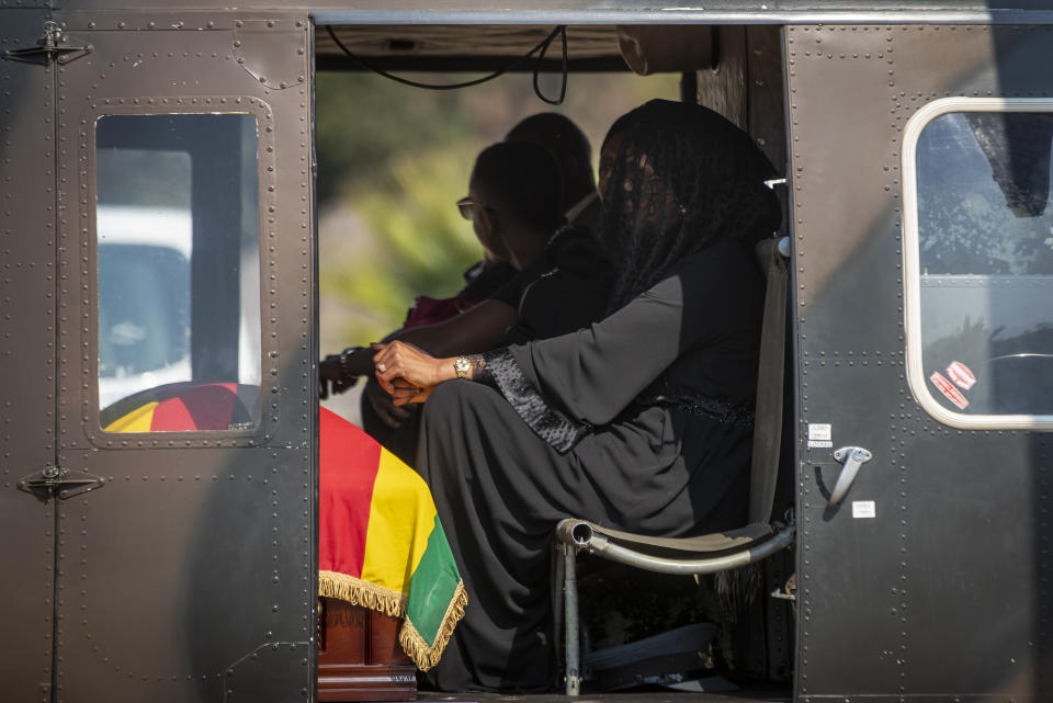 The casket of former president Robert Mugabe sits by the feet of widow Grace Mugabe, as she wears a black veil in an air force helicopter transporting the casket to a stadium where it will lie in state, at his official residence in the capital Harare, Zimbabwe Thursday, Sept. 12, 2019. Controversy over where and when Robert Mugabe will be buried has overshadowed arrangements for Zimbabweans to pay their respects to the deceased leader. (AP Photo/Ben Curtis)