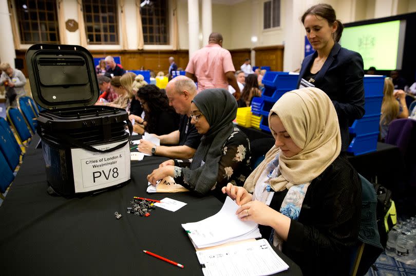 Counting staff count ballots at a counting centre in Methodist Central Hall, Westminster