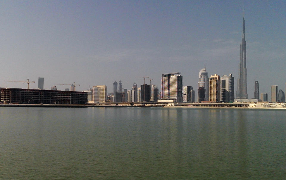 In this Jan. 30, 2014 photo, construction work is being carried on the Dubai Design District project, left, with the background of city skyline in Dubai, United Arab Emirates. Dubai and luxury are nearly synonymous. The city is home to the world’s tallest tower, massive manmade islands in the shape of palm trees and a fleet of police cars that include a Ferrari, Lamborghini and a $2.5 million Bugatti Veyron. To boost its glamour factor and economy, the city has its eyes set on the multi-billion dollar a year global fashion industry, which is currently dominated by the U.S., Europe and Japan. (AP Photo/Aya Batrawy)