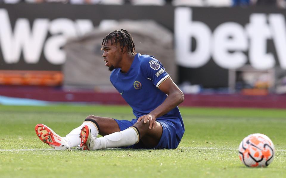 Carney Chukwuemeka of Chelsea sits on the floor after picking up an injury and later receiving medical treatment during the Premier League match