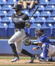 Toronto Blue Jays catcher Alejandro Kirk, right, looks on as New York Yankees' Giancarlo Stanton hits a single off Toronto starter Thomas Hatch during the first inning of a spring training baseball game Wednesday, March 17, 2021, at TD Ballpark in Dunedin, Fla. (Steve Nesius/The Canadian Press via AP)