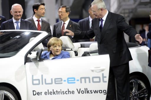 German Chancellor Angela Merkel tries out an electric Golf convertible watched by CEO Martin Winterkorn during a visit to the Volkswagen plant in Wolfsburg on Monday. Europe's biggest car maker has announced that it got off to a "successful" start to 2012, with net profit nearly doubling in the first three months