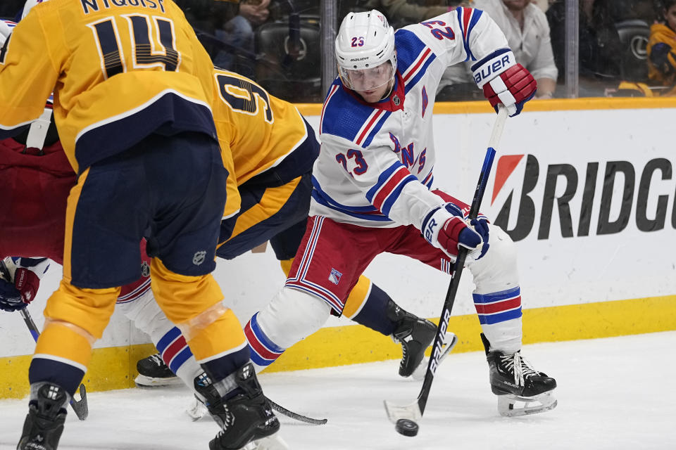 New York Rangers defenseman Adam Fox (23) passes the puck during the second period of an NHL hockey game against the Nashville Predators, Saturday, Dec. 2, 2023, in Nashville, Tenn. (AP Photo/George Walker IV)