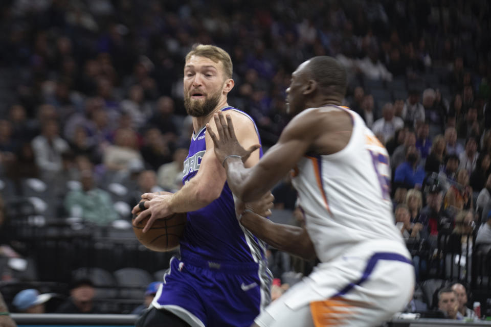 Sacramento Kings forward Domantas Sabonis, left, is defended by Phoenix Suns center Bismack Biyombo, right, in the first quarter in an NBA basketball game in Sacramento, Calif., Friday, March 24, 2023. (AP Photo/José Luis Villegas)