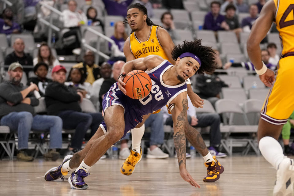 TCU guard Micah Peavy, front, loses his footing while getting past Arizona State guard Frankie Collins, rear, during the first half of an NCAA college basketball game in Fort Worth, Texas, Saturday, Dec. 16, 2023. (AP Photo/Tony Gutierrez)