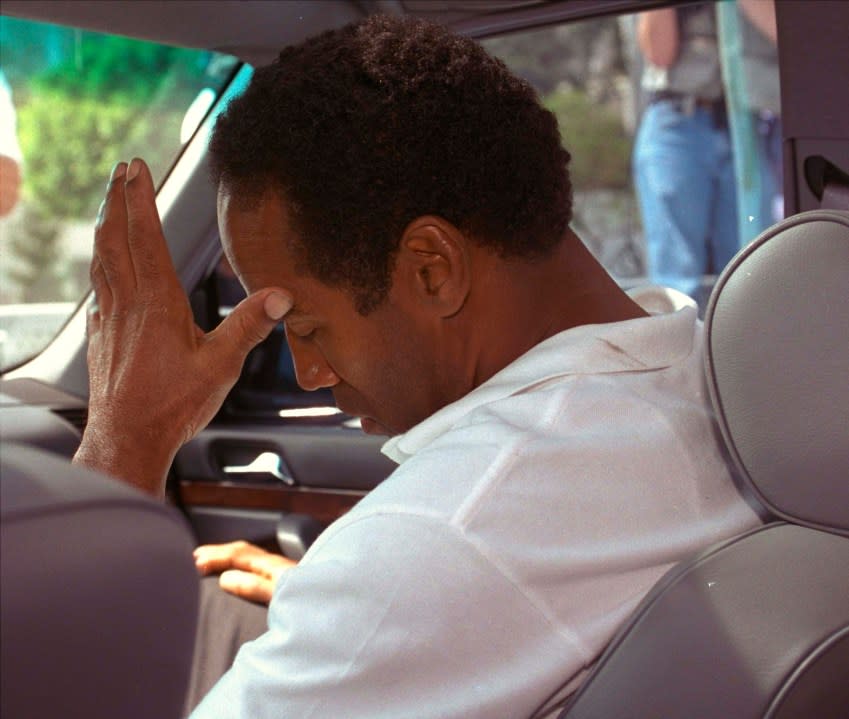 FILE – In this June 13, 1994, file photo, former pro running back O.J. Simpson hangs his head as he sits in his attorney’s car after being questioned by Los Angeles Police into the death of his ex-wife, Nicole Brown Simpson. The bodies of the 35-year-old woman and an unidentified 26-year-old man, apparent stabbing victims, were discovered after midnight Sunday in her Los Angeles area home. (AP Photo/Nick Ut, File)