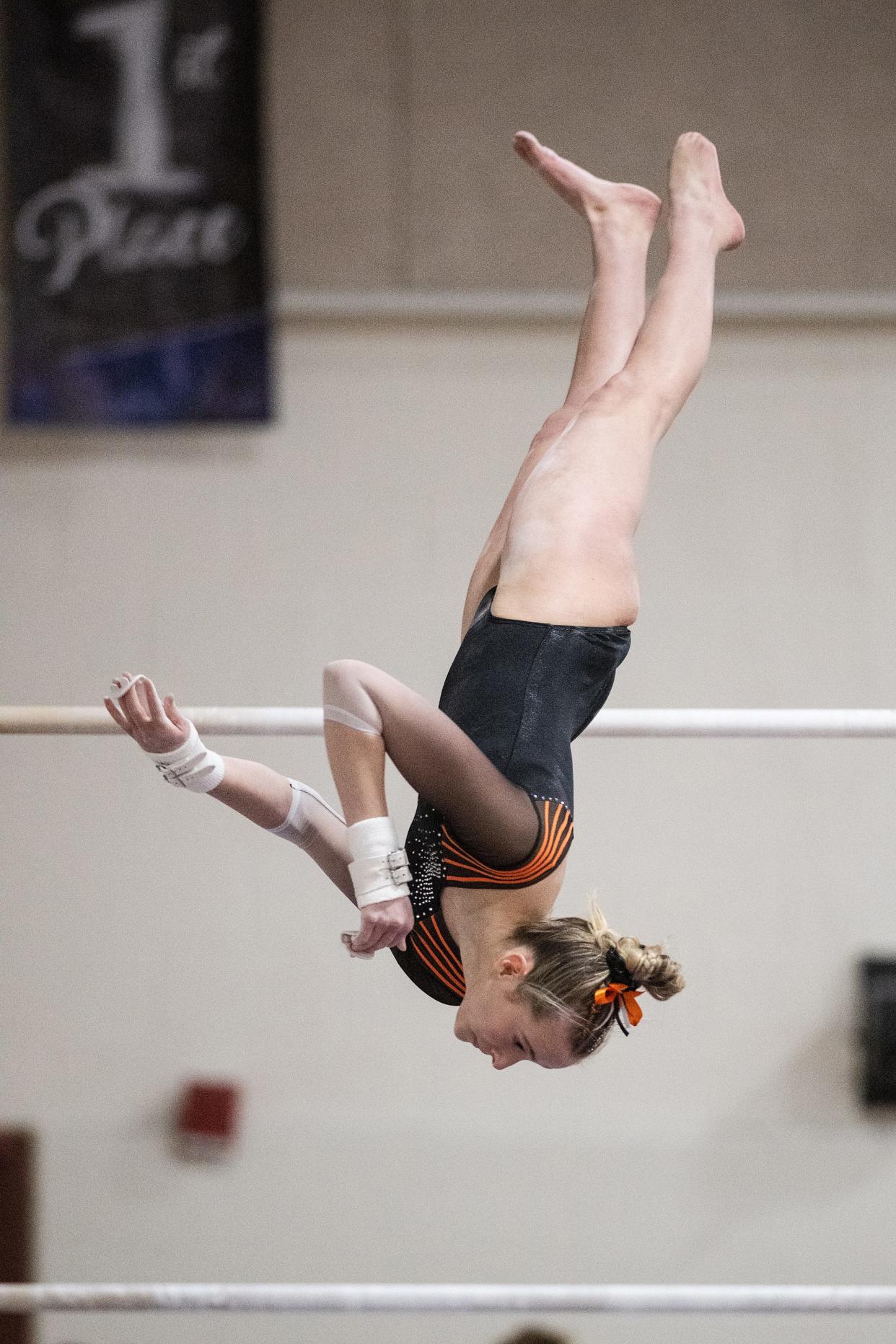 Marlborough's Eliza Rein dismounts from the bars at the Mid-Wach gymnastics championship.