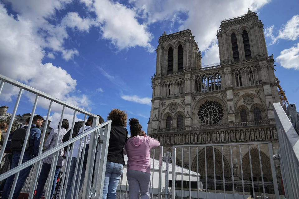 FILE - People have a close look of Notre Dame cathedral as they visit the rebuilding site during Heritage Day in Paris, Saturday, Sept. 17, 2022. France's Notre Dame Cathedral's reconstruction is progressing enough to allow its reopening to visitors and masses at the end of next year, less than six years after the after the shocking fire that tore through its roof, French officials said as an exhibit pays tribute to hundreds of artisans working on it. (AP Photo/Michel Euler, File)