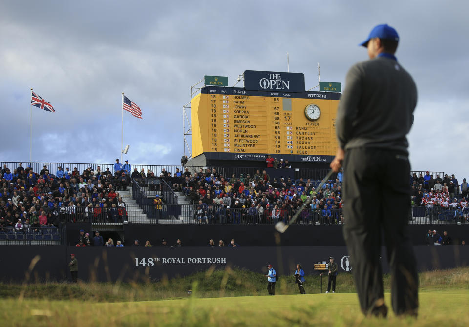 Tiger Woods of the United States prepares to chip onto the 18th green, as the scoreboard shows the leading players and Woods score been at bottom left, during the first round of the British Open Golf Championships at Royal Portrush in Northern Ireland, Thursday, July 18, 2019.(AP Photo/Jon Super)
