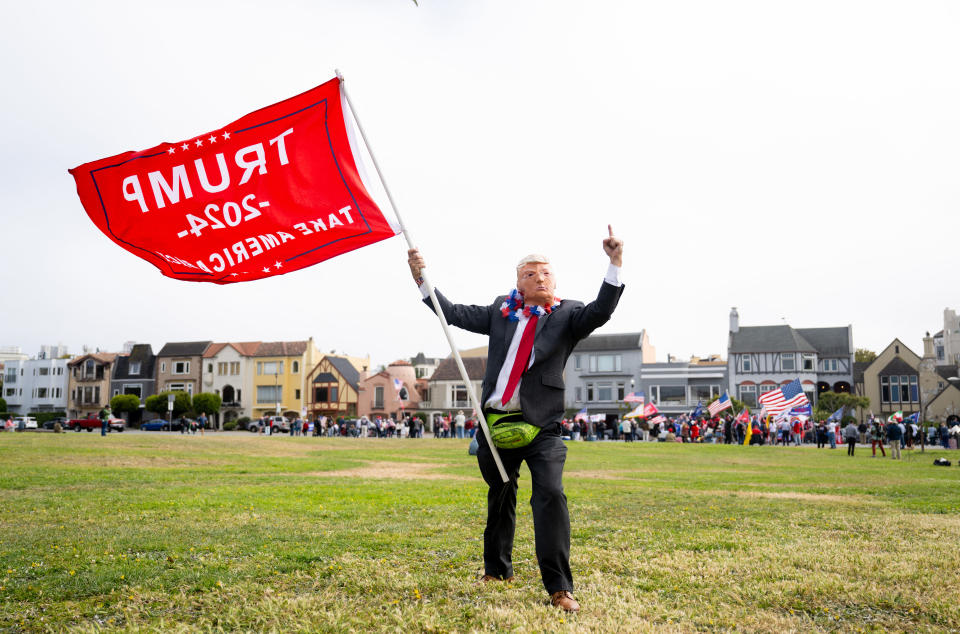 A supporter wears a mask of Donald Trump as people rally in anticipation of former US President Donald Trump's arrival to a fundraising event in San Francisco on June 6, 2024. (Photo by JOSH EDELSON / AFP) (Photo by JOSH EDELSON/AFP via Getty Images)