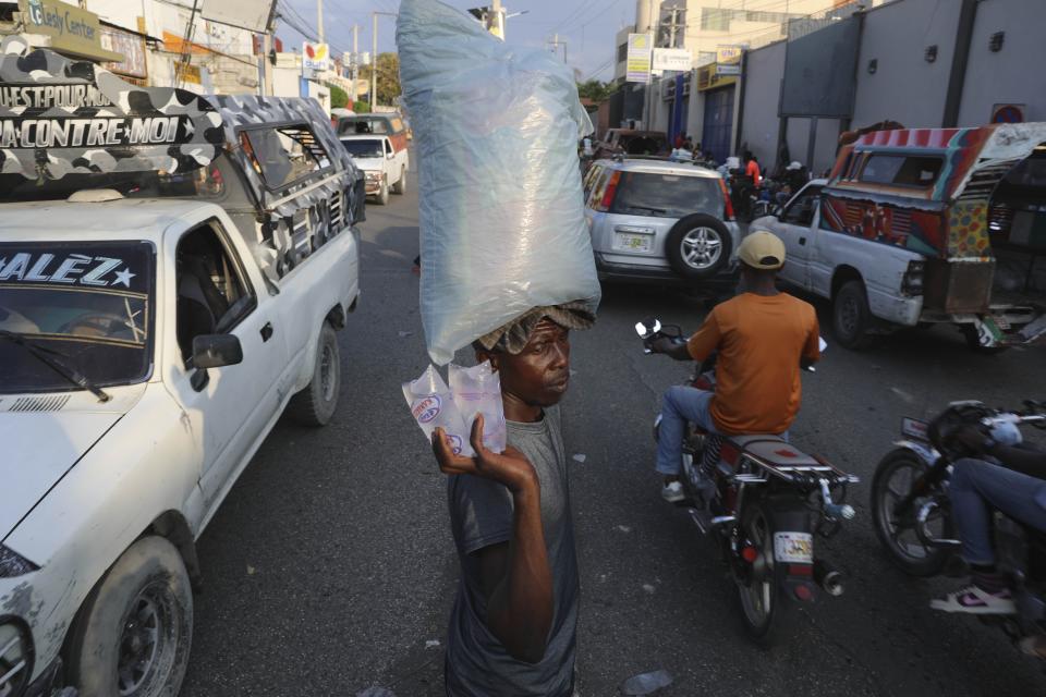 FILE - A vendor balances on his head a bag filled with smaller bags of water in the streets of Port-au-Prince, Haiti, Wednesday, April 10, 2024. (AP Photo/Odelyn Joseph, File)