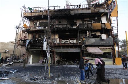 People gather at the site of a bomb attack in Baghdad's Karrada district February 18, 2014. REUTERS/Ahmed Saad