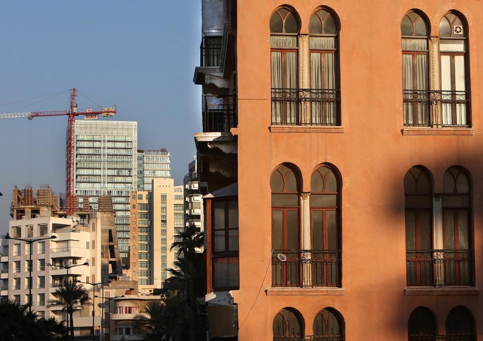 In this February 18, 2014 photo, an old building, right, is overshadowed by newly-built apartment buildings, some still under construction, in Beirut, Lebanon. Lebanon’s enchanting Ottoman and colonial French-style buildings once represented Beirut's rich history, withstanding years of civil war and invasions only to be demolished in peace time by wealthy Gulf Arab investors. While Lebanon's real estate sector has developed to become one of the country's success stories, many say it is coming at the expense of Lebanon's identity and heritage. (AP Photo/Hussein Malla)