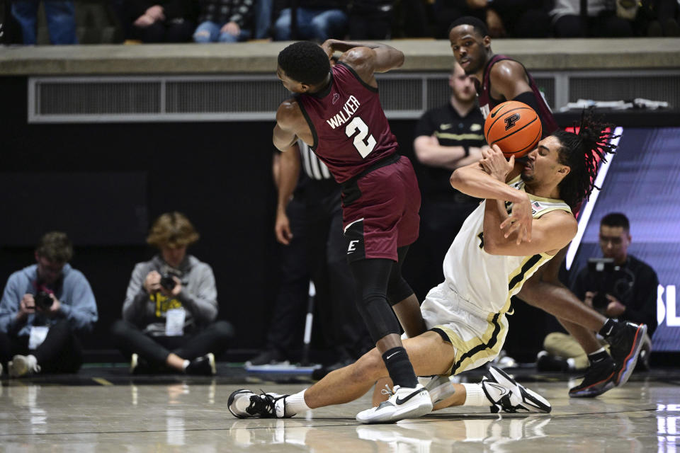 Purdue forward Trey Kaufman-Renn is hit on the face with the ball after losing control of it next to Eastern Kentucky guard Leland Walker (2) during the second half of an NCAA college basketball game Friday, Dec. 29, 2023, in West Lafayette, Ind. (AP Photo/Marc Lebryk)